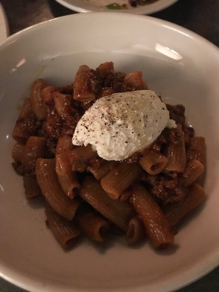 rigatoni pasta with meat sauce and whipped ricotta on top